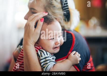 Nonna cullare pianto bambino ragazza che guarda la macchina fotografica Foto Stock