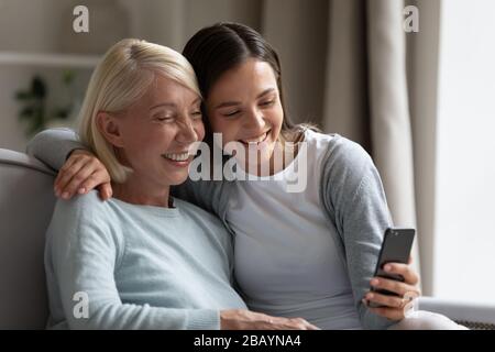 Sorridente mamma e la figlia cresciuta prendono selfie insieme Foto Stock