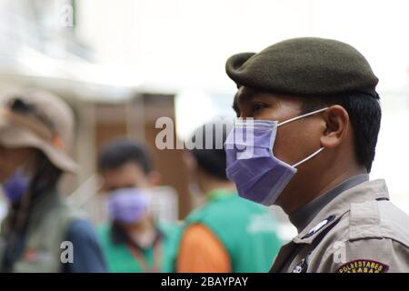 Makassar, Sulawesi meridionale, Indonesia. 30th Mar, 2020. Membro della polizia regionale del Sud Sulawesi, l'Indonesia indossa una maschera quando si svolgono compiti di pattuglia per le strade per prevenire lo scoppio del coronavirus (covid-19). La campagna del governo indonesiano per prevenire la diffusione dell'epidemia di Covid-19 chiedendo ai residenti di lavarsi sempre le mani e di indossare le maschere quando lasciano la casa. Credito: Herwin Bahar/ZUMA Wire/Alamy Live News Foto Stock