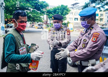 Makassar, Sulawesi meridionale, Indonesia. 30th Mar, 2020. Le mani di alcuni ufficiali della polizia regionale del Sulawesi meridionale, Indonesia, sono state spruzzate usando liquido disinfettante per pulire e prevenire il coronavirus (covid-19). La campagna del governo indonesiano per prevenire la diffusione dell'epidemia di Covid-19 chiedendo ai residenti di lavarsi sempre le mani e di indossare le maschere quando lasciano la casa. Credito: Herwin Bahar/ZUMA Wire/Alamy Live News Foto Stock