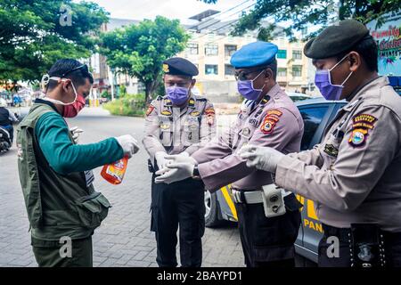 Makassar, Sulawesi meridionale, Indonesia. 30th Mar, 2020. Le mani di alcuni ufficiali della polizia regionale del Sulawesi meridionale, Indonesia, sono state spruzzate usando liquido disinfettante per pulire e prevenire il coronavirus (covid-19). La campagna del governo indonesiano per prevenire la diffusione dell'epidemia di Covid-19 chiedendo ai residenti di lavarsi sempre le mani e di indossare le maschere quando lasciano la casa. Credito: Herwin Bahar/ZUMA Wire/Alamy Live News Foto Stock