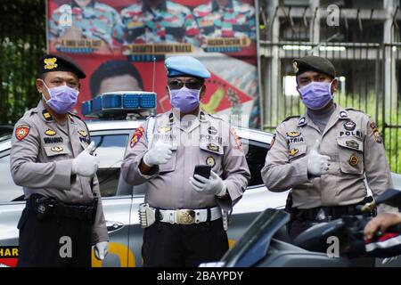 Makassar, Sulawesi meridionale, Indonesia. 30th Mar, 2020. Alcuni ufficiali della polizia regionale del Sulawesi meridionale, Indonesia, indossano maschere quando svolgono compiti di pattuglia per le strade per prevenire lo scoppio del coronavirus (covid-19). La campagna del governo indonesiano per prevenire la diffusione dell'epidemia di Covid-19 chiedendo ai residenti di lavarsi sempre le mani e di indossare le maschere quando lasciano la casa. Credito: Herwin Bahar/ZUMA Wire/Alamy Live News Foto Stock