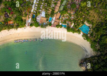 Vista aerea dei droni sulle barche intorno a una splendida spiaggia tropicale (Railay Beach West, Krabi, Thailandia) Foto Stock