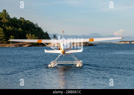 Un idrovolante giallo e bianco Cessna 172 Skyhawk per il decollo tra le isole dell'arcipelago di Kragerø, sulla costa meridionale della Norvegia. Foto Stock