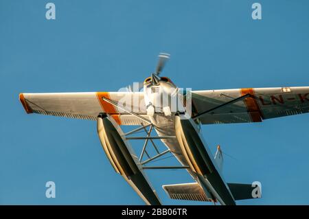 Primo piano di un idrovolante giallo e bianco Cessna 172 Skyhawk che parte tra le isole dell'arcipelago di Kragerø sulla costa meridionale della Norvegia. Foto Stock