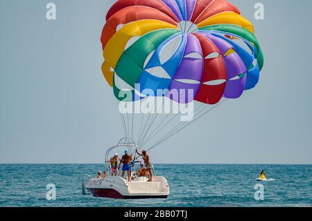 Vacanzieri para vela da barca a motore con paracadute colorato sul Mar Nero Varna Bulgaria Foto Stock