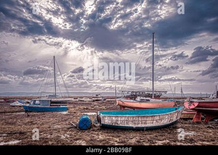 Barche in camicia in attesa della marea sul marshland a Lower Heswall ormeggi cantiere Banks Road sul fiume Dee Estuary, Wirral, Regno Unito Foto Stock