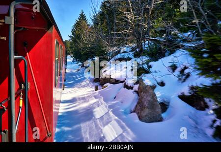 Giro in locomotiva a vapore in inverno con neve. Dinamica attraverso la sfocatura del movimento. Foto Stock