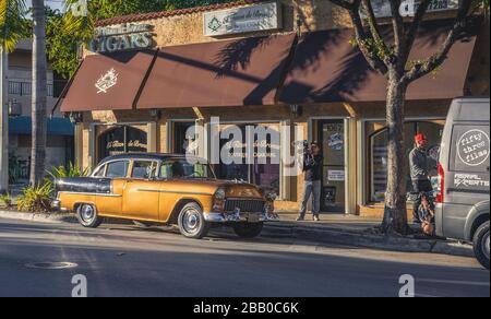 01 04 2016 - Miami, Florida, Stati Uniti d'America. Set di film con una vecchia vettura americana lucida di fronte a un negozio di sigari nel quartiere cubano. Foto Stock