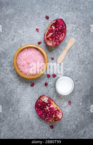 Vista dall'alto dei cosmetici di frutta a melograno su sfondo grigio. Foto Stock