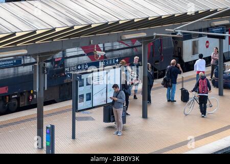 Persone in attesa dell'arrivo del treno alla stazione centrale di Copenhagen, Copenhagen, Danimarca, Europa Foto Stock