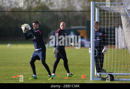 Il portiere dell'Inghilterra, Fraser Forster, salva la palla guardata da John Ruddy e Joe Hart durante l'allenamento Foto Stock