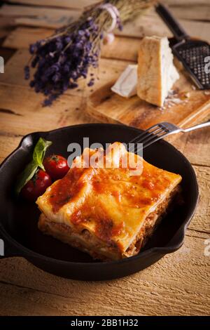 Cucina italiana mediterranea Lasagna Bolognese in padella su tavola rustica in legno Foto Stock