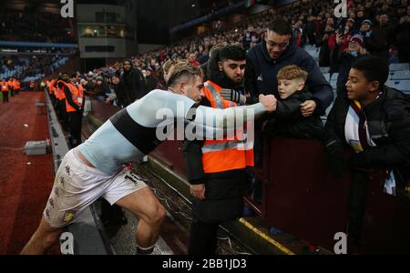 Il Jack Grealish di Aston Villa regala la fascia da braccio del suo capitano a un giovane fan dopo il gioco Foto Stock