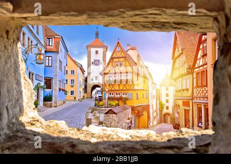 Strada acciottolata e architettura della città storica di Rothenburg ob der Tauber vista attraverso finestra di pietra, strada romantica della Baviera regione della Germania Foto Stock