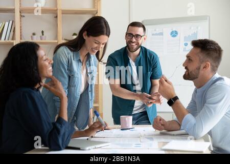 Sorridere colleghi diversi ridere collaborare a briefing Foto Stock