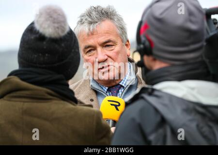 Nigel Twiston-Davies l'allenatore di Cogry guidato da Sam Twiston-Davies è intervistato in recinto vincitori durante il giorno uno del meeting internazionale a Cheltenham Racecourse, Cheltenham. Foto Stock