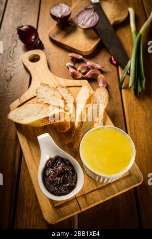 Foie gras con marmellata di cipolle e toast su piastra di legno rustico Foto Stock