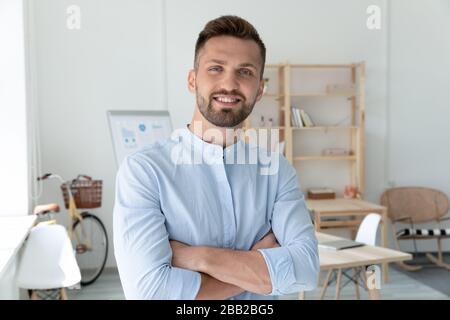 Sorridente uomo caucasico che posa in ufficio Foto Stock