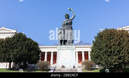 Statua della Baviera con Ruhmeshalle (sala di fama) sullo sfondo. Situato a Theresienwiese. Punto di riferimento e popolare destinazione turistica. Foto Stock