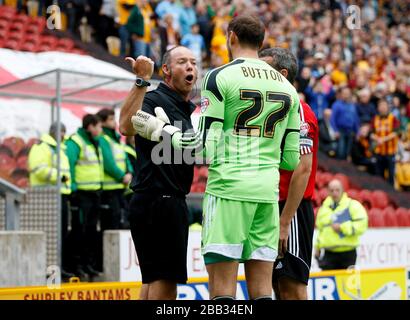 Andy Haines, arbitro, invia David Button al portiere di Brentford per un serio gioco di fallo Foto Stock