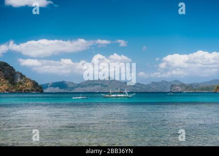 Filippino barche in oceano aperto nella baia di El Nido. Isole forme in background. Isola di Palawan, Filippine Foto Stock