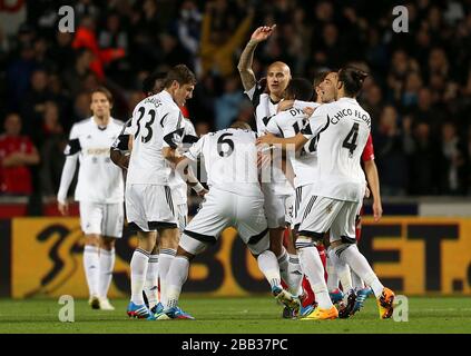 Jonjo Shelvey (centro) di Swansea City festeggia con i suoi compagni di squadra dopo aver segnato il primo gol del gioco Foto Stock