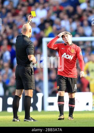 Wayne Rooney (a destra) del Manchester United è prenotato tramite l'arbitro Howard Webb per un fallo su Vincent Kompany (non in foto) di Manchester City Foto Stock