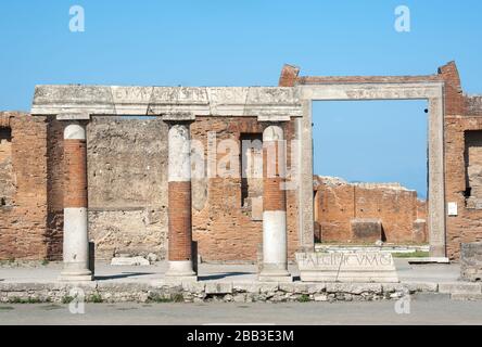 Colonnato con iscrizioni latine di fronte all'edificio di Eumachia, Pompei, Italia Foto Stock