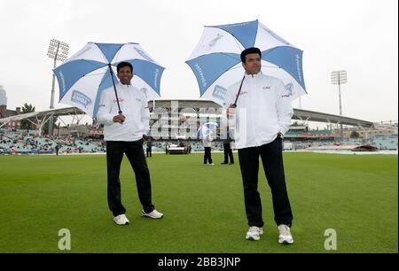 Gli imperi Aleem Dar (a destra) e Kumar Dharmasena ispezionano il tempo del quarto giorno del quinto test Ashes al Kia Oval mentre la pioggia ritarda l'inizio del gioco Foto Stock