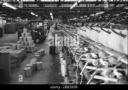 Un lavoratore che supervisiona una macchina al mulino Tay Spinners di Dundee, in Scozia. Questo stabilimento è stato l'ultimo filatoio di iuta in Europa quando è stato chiuso per l'ultima volta nel 1998. La città di Dundee era stata famosa per la storia dei tre 'JS' - juta, jam e giornalismo. Foto Stock