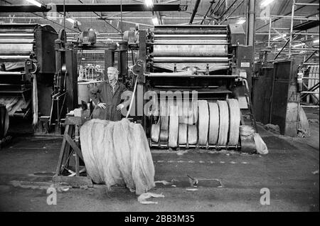 Un lavoratore che supervisiona una macchina al mulino Tay Spinners di Dundee, in Scozia. Questo stabilimento è stato l'ultimo filatoio di iuta in Europa quando è stato chiuso per l'ultima volta nel 1998. La città di Dundee era stata famosa per la storia dei tre 'JS' - juta, jam e giornalismo. Foto Stock