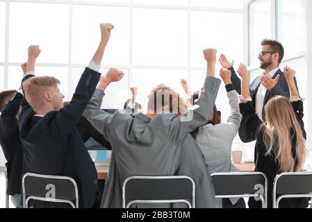 Un team di lavoro felice seduto al banco dell'ufficio Foto Stock