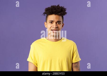 Ritratto della vita di giovane interessato uomo ispanico con sguardo preoccupato guardando la macchina fotografica, accigliando di essere spaventato per amico bloccato in situazione fastidiosa Foto Stock