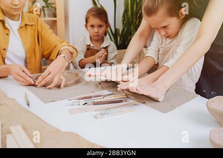 una classe studentesca in scultura e ceramica. Bambini e adulti si sono impegnati insieme al tavolo, modellando da argilla Foto Stock