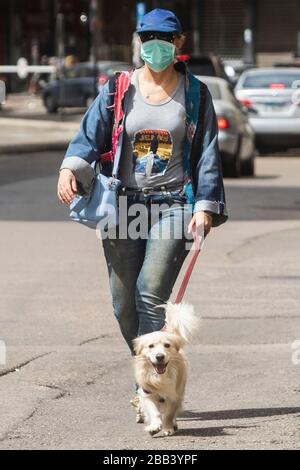 Beirut, Libano. 30 marzo 2020. Una donna pedone che indossa una maschera chirurgica protettiva che cammina il suo cane per strada durante il blocco che è stato esteso fino al 12 aprile 2020 per arginare la diffusione di covid-19 coronavirus. Credit: amer ghazzal/Alamy Live News Foto Stock