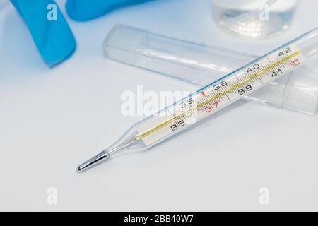 Termometro macro, strumento a mercurio, misurazione, indicazione della temperatura strumento medico su sfondo bianco Foto Stock