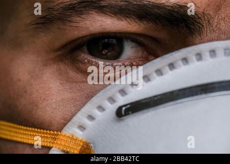 Uomo occhio ritratto dettagli medicazione corona virus covid-19 maschera protettiva, malattia Foto Stock