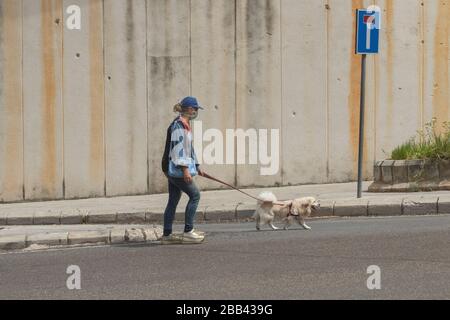 Beirut, Libano. 30 marzo 2020. Una donna pedone che cammina il suo cane in strada durante il blocco che è stato esteso fino al 12 aprile 2020 per arginare la diffusione di covid-19 coronavirus. Credit: amer ghazzal/Alamy Live News Foto Stock