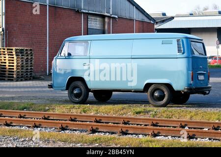 Bus VW azzurro accanto alle rotaie nel porto di spedizione di Düsseldorf . Foto Stock