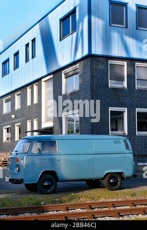 Bus VW azzurro accanto alle rotaie nel porto di spedizione di Düsseldorf . Foto Stock