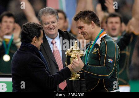 Il presidente francese Nicolas Sarkozy (a sinistra) presenta il capitano vincitore John Smit (Sudafrica, capitano, a destra) con il Webb Ellis Trophy. Guardato da me Foto Stock