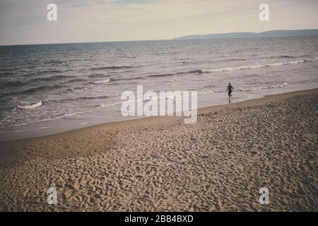 Lady Running sulla spiaggia di Bournemouth Foto Stock