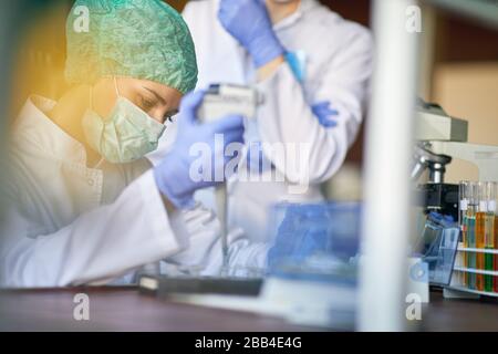 femmina sciallit fare ricerca in laboratorio analisi di un nuovo virus. corona virus concetto Foto Stock