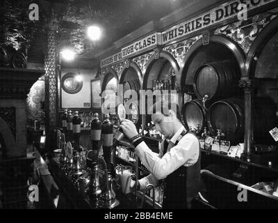 Un barman che tira una pinta di Guinness nella Corona, uno dei pub più famosi e amati di Belfast. Foto Stock