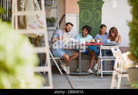 Giovane gruppo di studenti seduti in un bar insieme Foto Stock