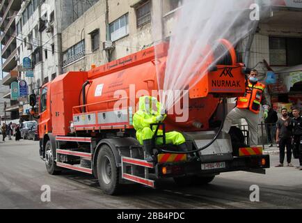 Gaza. 30th Mar, 2020. I lavoratori palestinesi sterilizzano una strada nella città di Gaza, il 30 marzo 2020. Credit: Rizek Abdeljawad/Xinhua/Alamy Live News Foto Stock