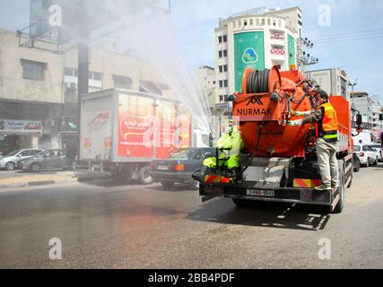 Gaza. 30th Mar, 2020. I lavoratori palestinesi sterilizzano una strada nella città di Gaza, il 30 marzo 2020. Credit: Rizek Abdeljawad/Xinhua/Alamy Live News Foto Stock