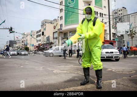 Gaza. 30th Mar, 2020. Un lavoratore palestinese sterilizza una strada nella città di Gaza, il 30 marzo 2020. Credit: Rizek Abdeljawad/Xinhua/Alamy Live News Foto Stock