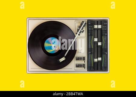 Giradischi vintage con disco rotante su sfondo giallo Foto Stock